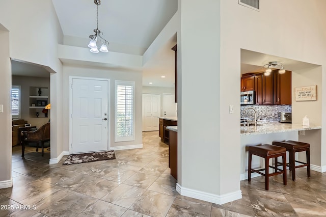 foyer entrance with high vaulted ceiling and sink