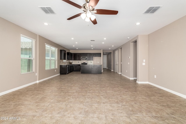 unfurnished living room with ceiling fan and tile patterned floors