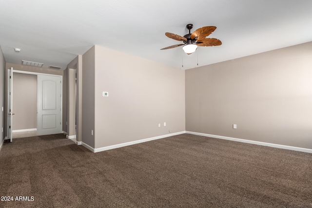 unfurnished room with dark colored carpet and ceiling fan