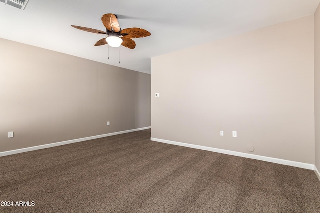 empty room with dark colored carpet, visible vents, baseboards, and ceiling fan