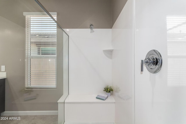 bathroom featuring baseboards, vanity, and walk in shower
