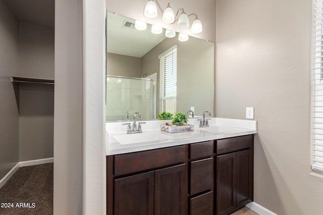 full bathroom with a shower stall, double vanity, visible vents, and a sink
