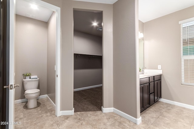 bathroom with visible vents, baseboards, toilet, tile patterned floors, and vanity