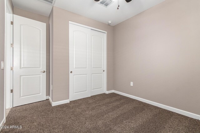 unfurnished bedroom with ceiling fan, a closet, and carpet flooring