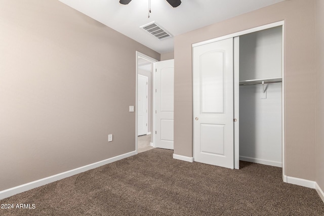 unfurnished bedroom featuring baseboards, visible vents, a closet, and dark colored carpet