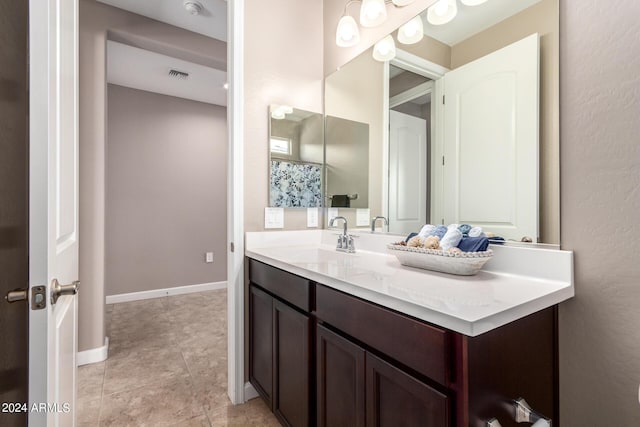 bathroom featuring baseboards, visible vents, tile patterned flooring, and vanity