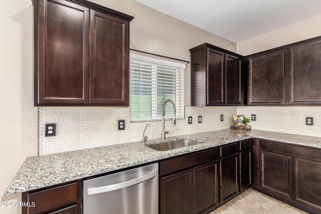 kitchen featuring a sink, backsplash, light stone countertops, and dishwasher