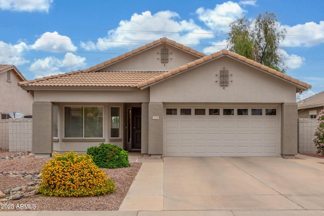 mediterranean / spanish house featuring concrete driveway, an attached garage, stucco siding, and a tile roof