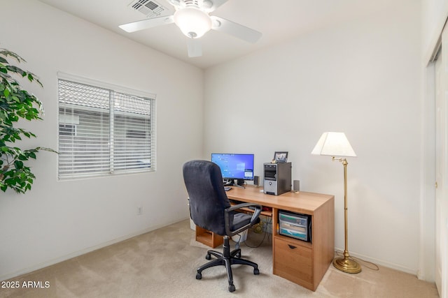office featuring light colored carpet, a ceiling fan, and baseboards