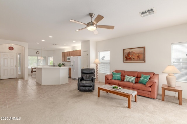 living room featuring plenty of natural light, a ceiling fan, light colored carpet, recessed lighting, and light tile patterned flooring