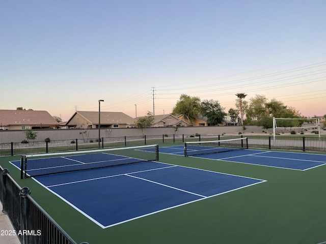 view of tennis court featuring fence and community basketball court