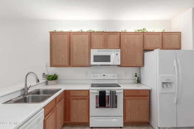 kitchen featuring white appliances, a sink, and light countertops
