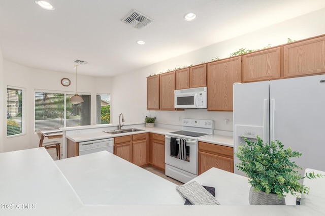 kitchen featuring white appliances, a sink, pendant lighting, light countertops, and recessed lighting