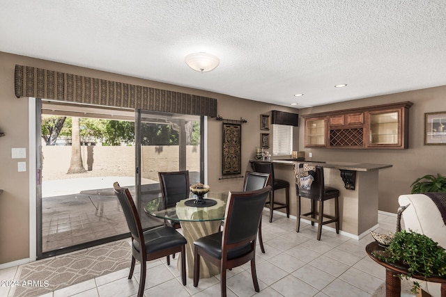 tiled dining area with a textured ceiling