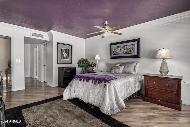 bedroom with crown molding, dark hardwood / wood-style floors, and ceiling fan