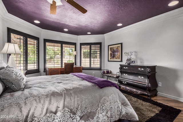 bedroom featuring ornamental molding, wood-type flooring, ceiling fan, and a textured ceiling