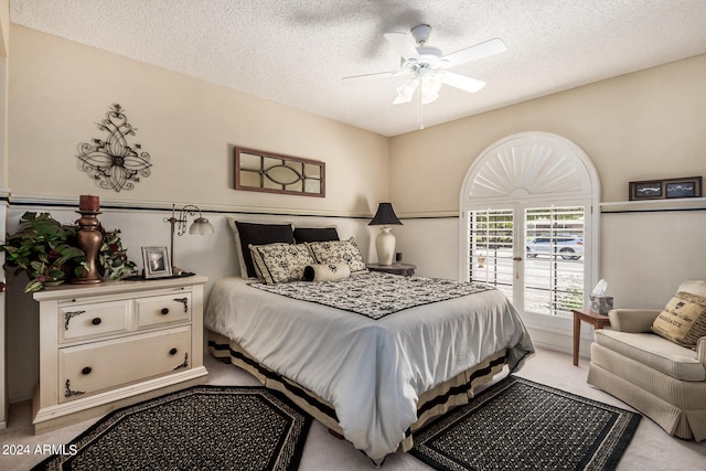 carpeted bedroom featuring ceiling fan and a textured ceiling