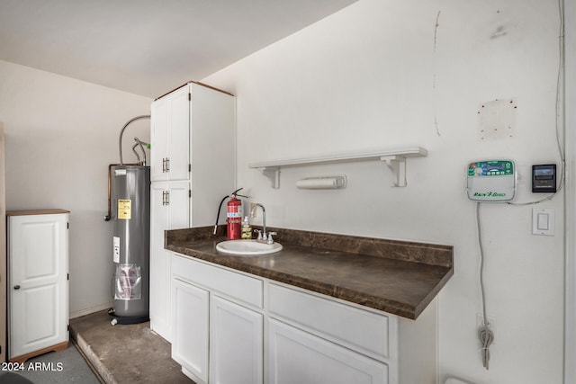 kitchen with electric water heater, white cabinets, and sink