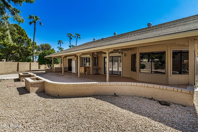 rear view of property with ceiling fan and a patio area