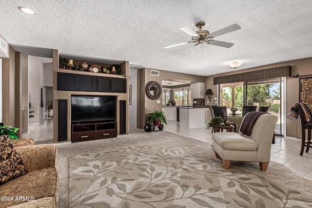 tiled living room with ceiling fan and a textured ceiling