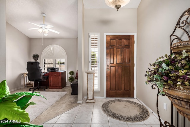 entryway featuring ceiling fan, a textured ceiling, and light tile patterned floors