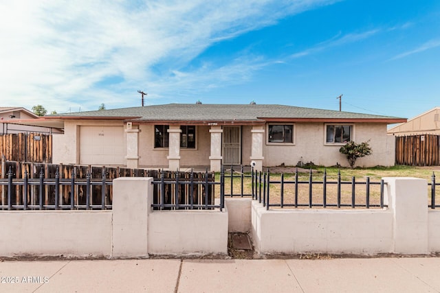 view of front of property featuring a garage, a fenced front yard, and stucco siding