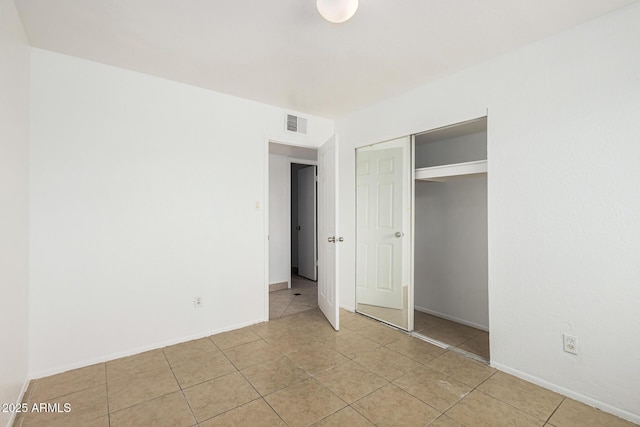 unfurnished bedroom with baseboards, visible vents, a closet, and light tile patterned flooring