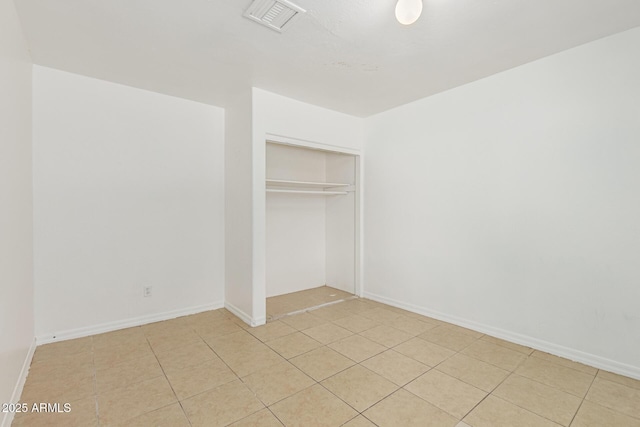 unfurnished bedroom with a closet, visible vents, and baseboards