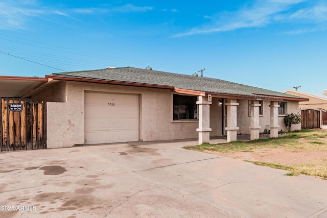 single story home with a shingled roof, concrete driveway, an attached garage, and stucco siding