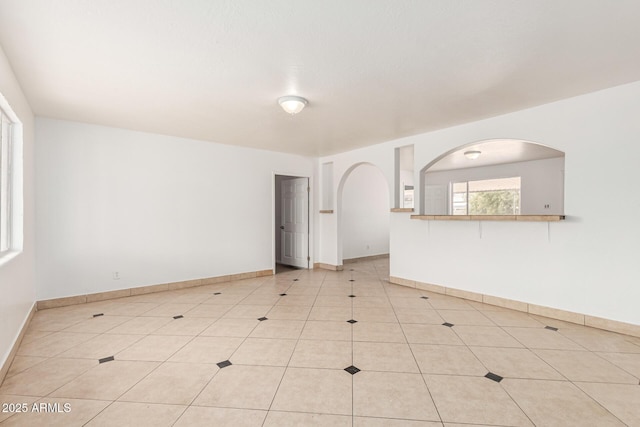 unfurnished room featuring baseboards and light tile patterned floors