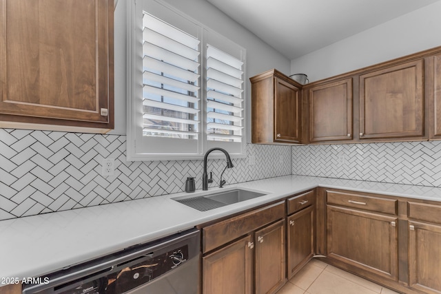 kitchen with tasteful backsplash, stainless steel dishwasher, sink, light tile patterned floors, and plenty of natural light