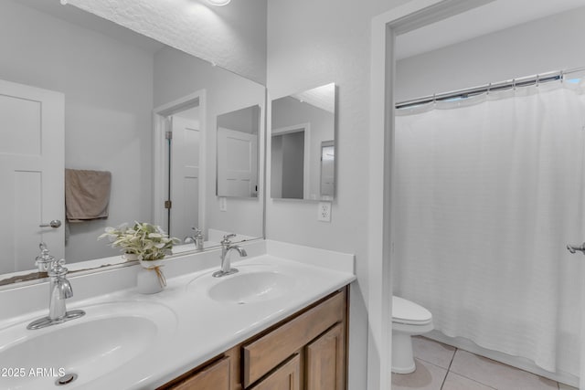 bathroom with tile patterned flooring, vanity, and toilet