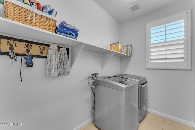 washroom with washing machine and dryer and light tile patterned floors