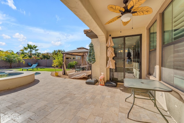 view of patio / terrace with a gazebo, ceiling fan, and a swimming pool