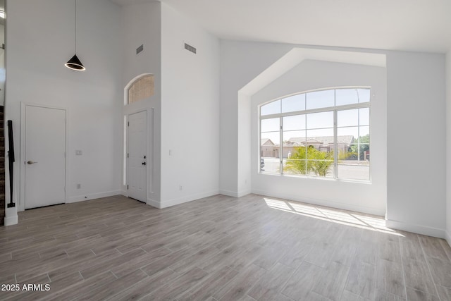 8478 W Grovers Ave, Peoria, AZ 85382 - unfurnished living room with wood finished floors and a high ceiling