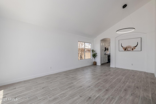 8478 W Grovers Ave, Peoria, AZ 85382 - unfurnished room featuring arched walkways, light wood-type flooring, and high vaulted ceiling