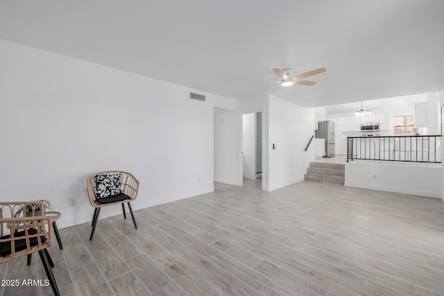 8478 W Grovers Ave, Peoria, AZ 85382 - living area featuring a ceiling fan, light wood finished floors, stairway, and a chandelier