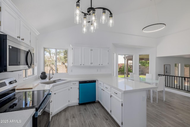 8478 W Grovers Ave, Peoria, AZ 85382 - kitchen with stainless steel appliances, a peninsula, vaulted ceiling, light countertops, and white cabinetry