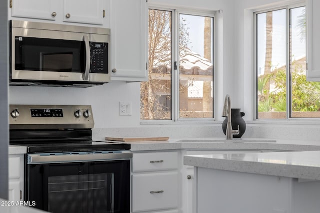 8478 W Grovers Ave, Peoria, AZ 85382 - kitchen with appliances with stainless steel finishes, white cabinetry, and light stone counters