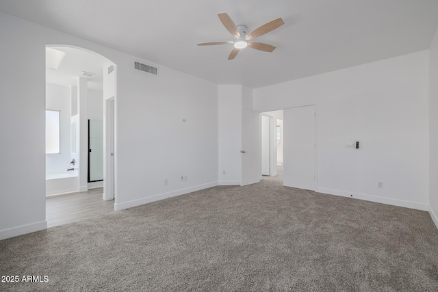 8478 W Grovers Ave, Peoria, AZ 85382 - empty room featuring ceiling fan, arched walkways, and carpet flooring
