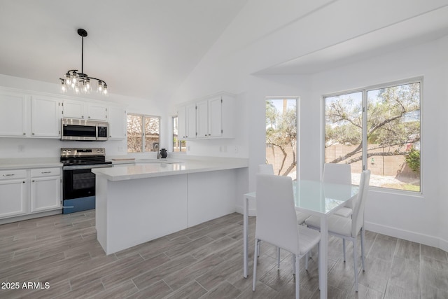 8478 W Grovers Ave, Peoria, AZ 85382 - kitchen with appliances with stainless steel finishes, light countertops, white cabinets, a peninsula, and high vaulted ceiling