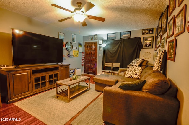 living room featuring hardwood / wood-style flooring, ceiling fan, and a textured ceiling