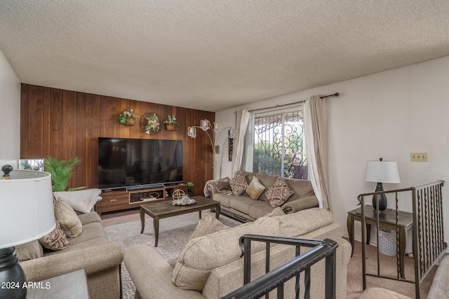 living room featuring wood walls and a textured ceiling