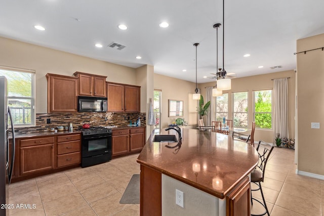 29159 N 128th Ln, Peoria, AZ 85383 - kitchen featuring black appliances, a sink, brown cabinetry, backsplash, and plenty of natural light