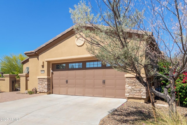 29159 N 128th Ln, Peoria, AZ 85383 - view of front of house featuring stone siding, driveway, stucco siding, a garage, and a gate