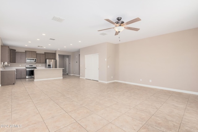 unfurnished living room with light tile patterned floors and ceiling fan