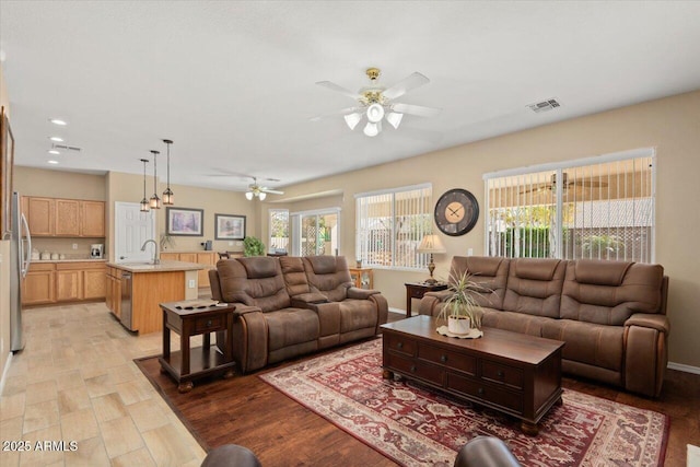 living area with a wealth of natural light, visible vents, and light wood-style flooring