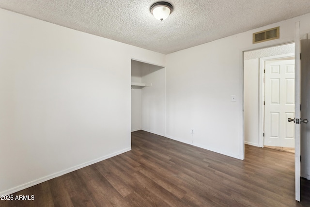 unfurnished room with dark hardwood / wood-style flooring and a textured ceiling