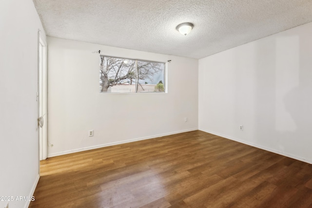 empty room with hardwood / wood-style flooring and a textured ceiling