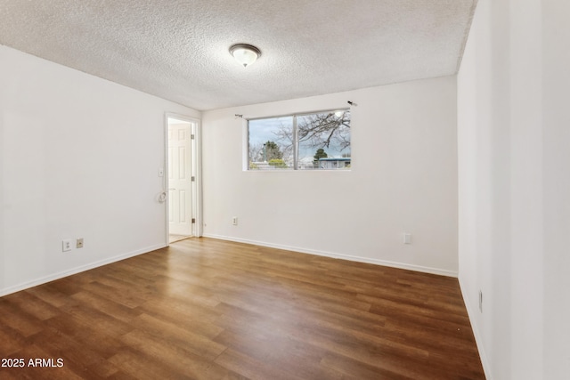 unfurnished room with dark wood-type flooring and a textured ceiling